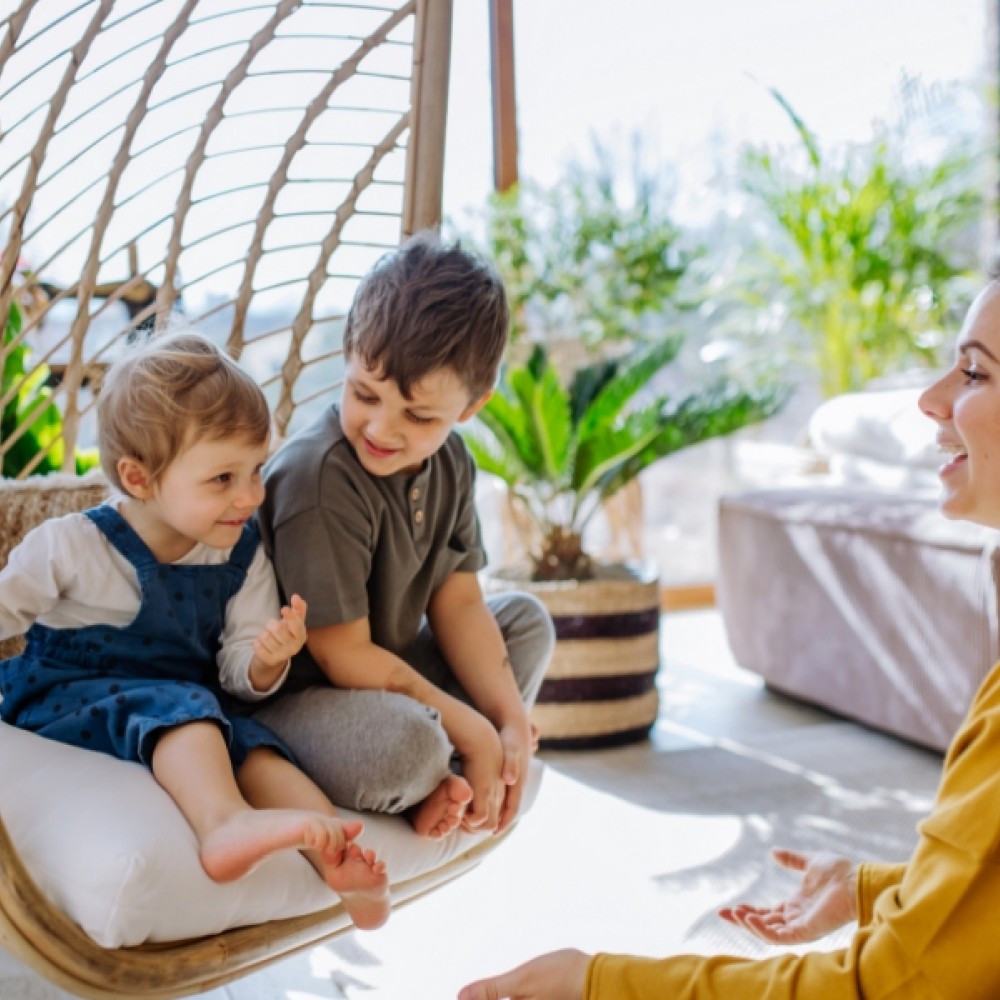 Mother talking to two children in a conservatory