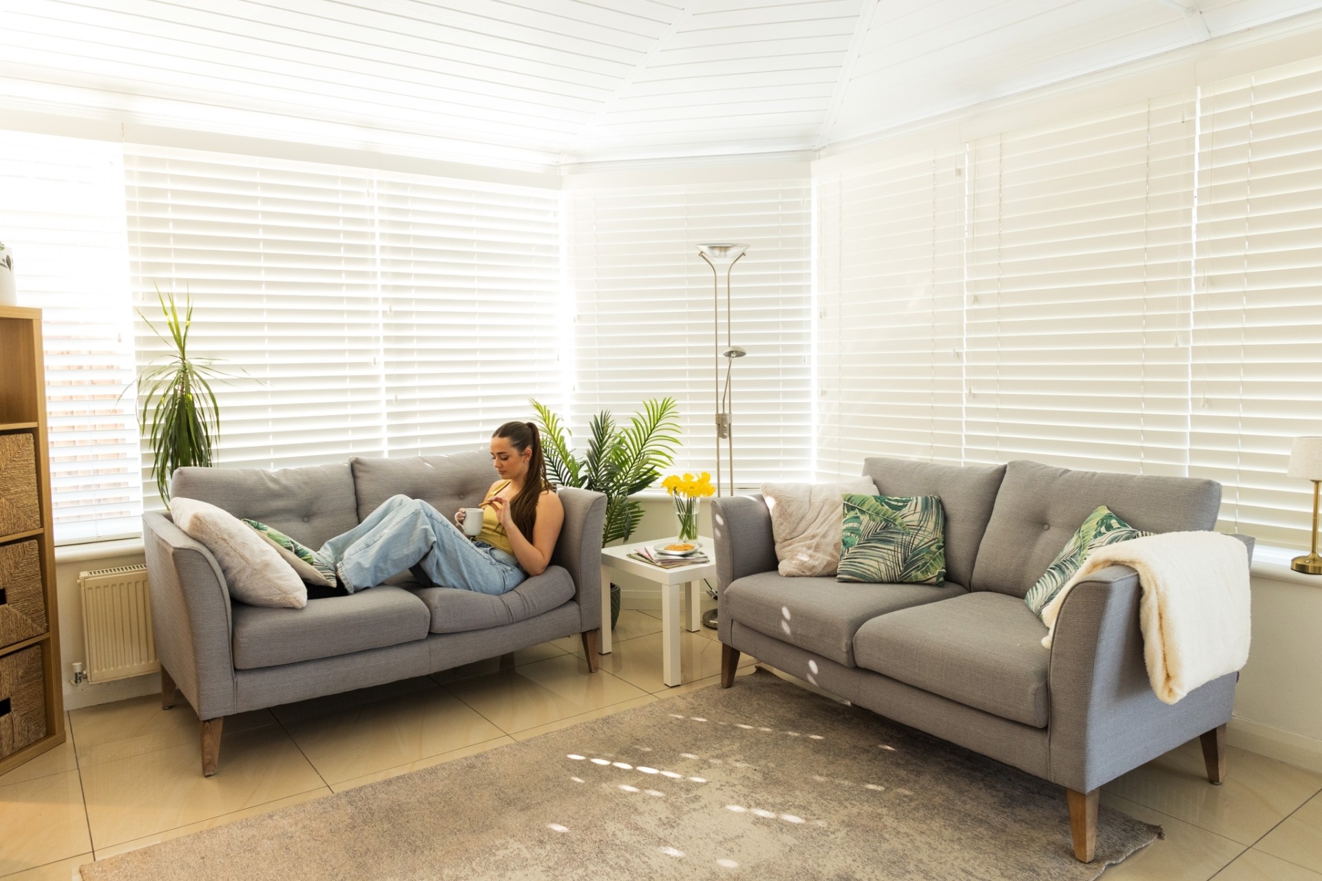 Woman relaxing in their insulated conservatory