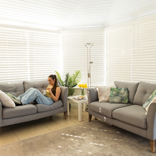 Woman relaxing in their insulated conservatory