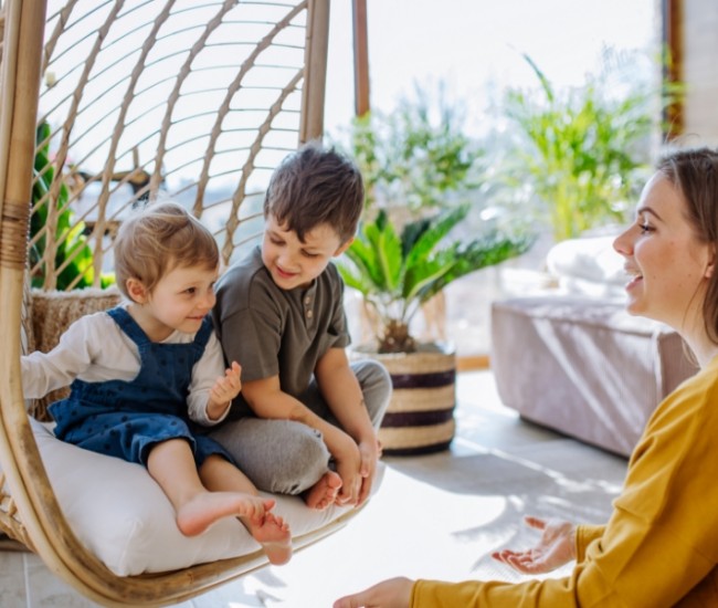 Mother talking to two children in a conservatory